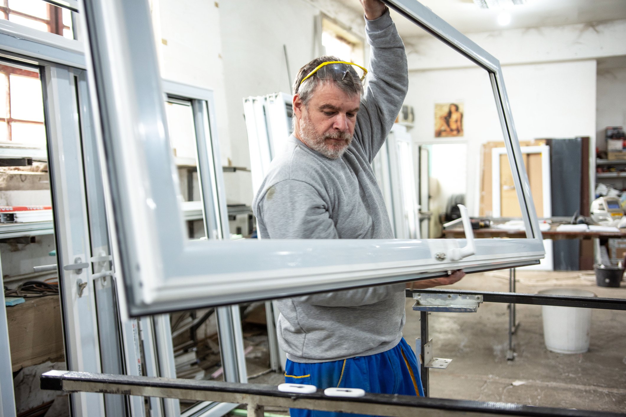 Manual worker assembling PVC doors and windows. Manufacturing jobs. Factory for aluminum and PVC windows and doors production.
